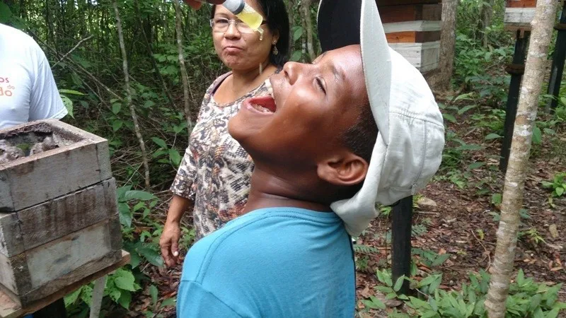 Vacina de mel em criança no Quilombo do Mel da Pedreira em Macapá-AP com a liderança do Parque Indígena do Tumucumaque Cecile Apalai